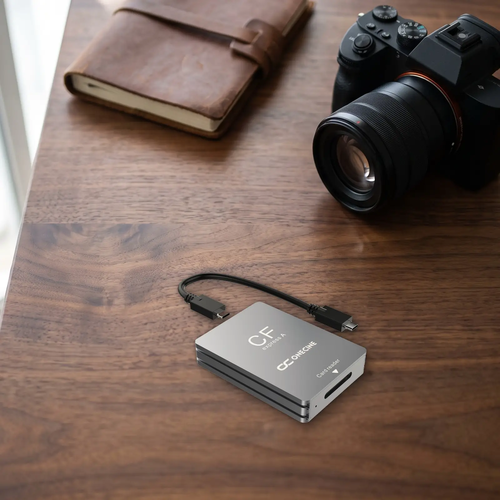 Картридер OneCine CFexpress Type A с кабелем USB-C на столе фотографа рядом с беззеркальной камерой