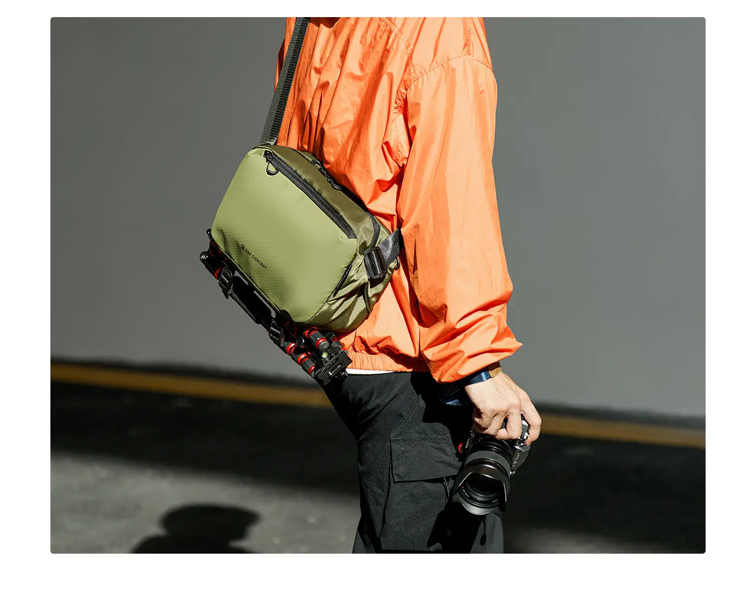 Сумка K&F Alpha Sling 10L (хаки) с компактным штативом, закреплённым нижними стропами, в городе