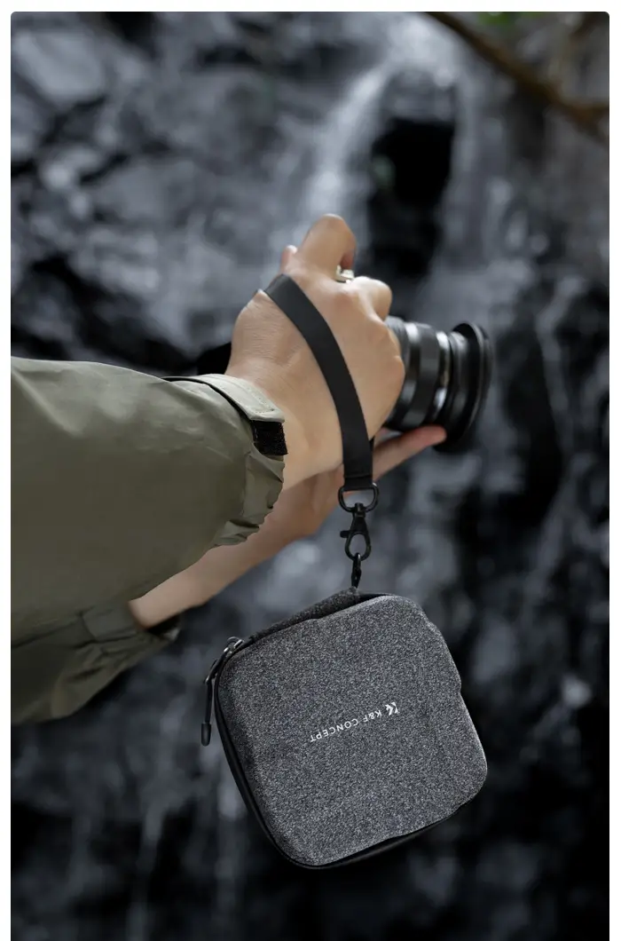 Кейс K&F KF13.175 висит на съёмном ремешке на запястье фотографа во время съёмки