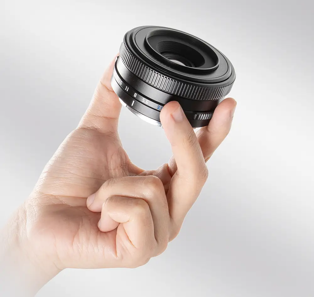 Объектив TTArtisan AF 14 мм F3.5 в пальцах — цельнометаллический корпус и кольцо диафрагмы