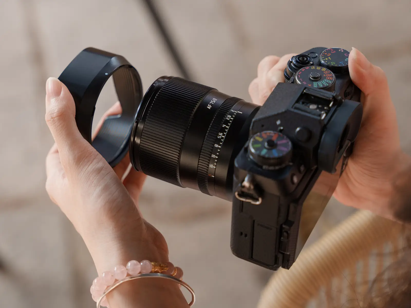 Установка байонетной бленды на объектив TTArtisan AF 75 мм F2, камера Fujifilm в руках