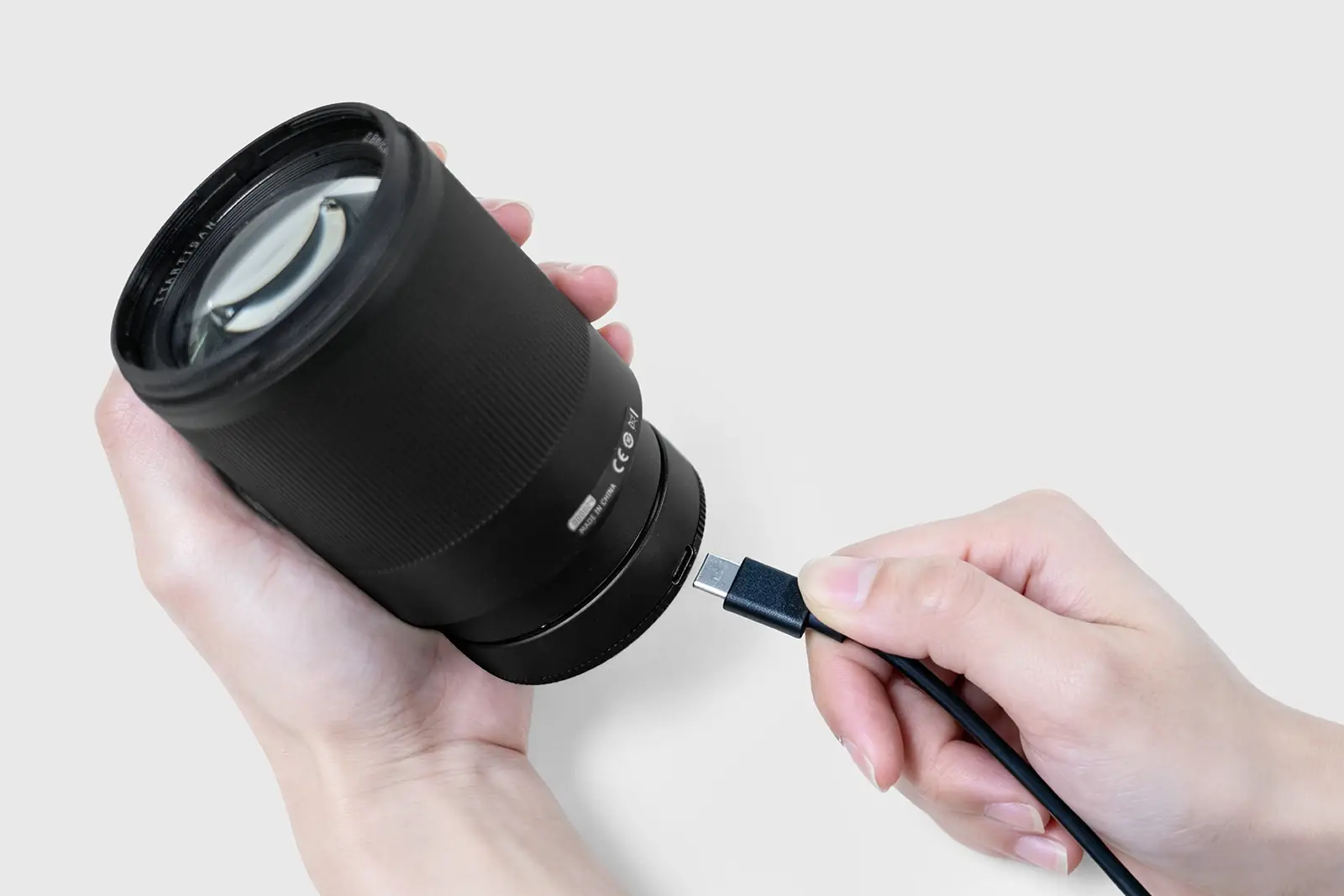 Объектив TTArtisan AF 85 мм F1.8 Neo с задней крышкой, в которую подключают кабель USB-C для обновления прошивки
