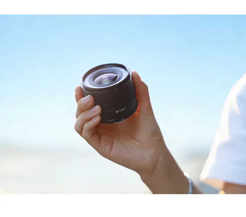 Металлический корпус объектива TTArtisan AF 17 мм F1.8 в руке