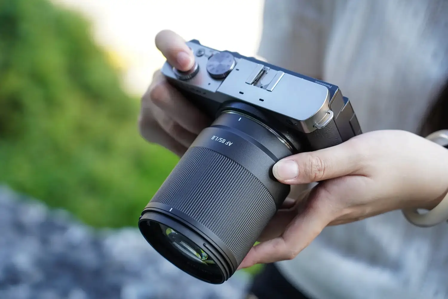 Камера Panasonic Lumix S9 с объективом TTArtisan AF 85 мм F1.8 Neo в руках фотографа