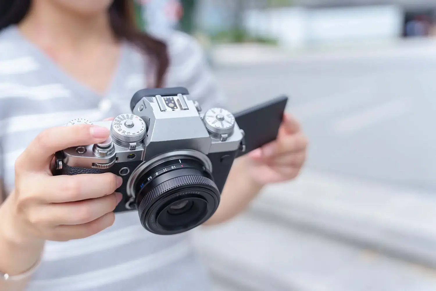 Камера Fujifilm X-T4 с объективом TTArtisan AF 14 мм F3.5 в руках на улице