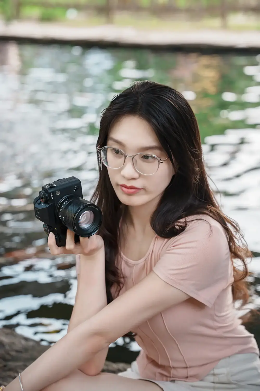 Девушка с камерой Fujifilm и объективом TTArtisan AF 75 мм F2 у воды