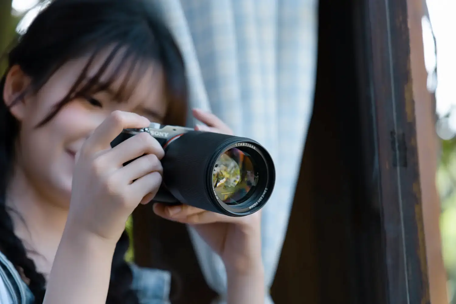 Девушка снимает на камеру Sony с объективом TTArtisan AF 85 мм F1.8 Neo
