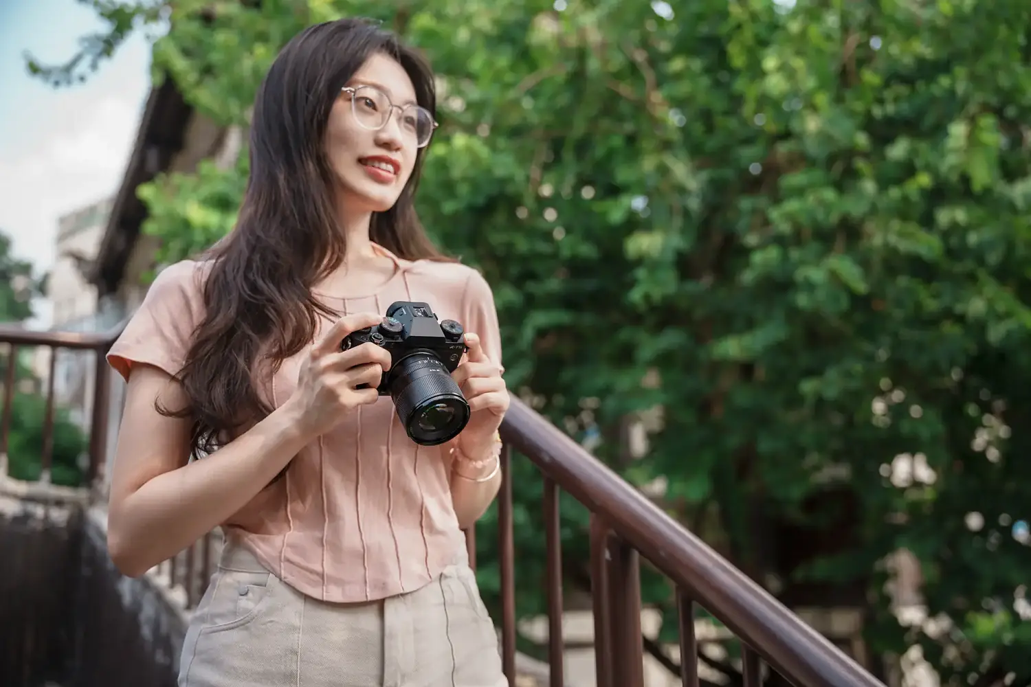 Камера Fujifilm с объективом TTArtisan AF 75 мм F2 в руках фотографа на улице
