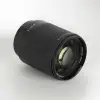 Объектив TTArtisan AF 85 мм F1.8 Neo для Sony E лежит на боку — передняя линза и маркировка 0,8 м / 62 мм
